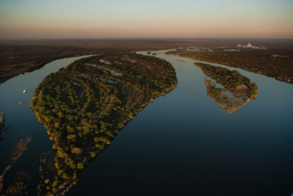 Aerial view of Zambian islands and the winding Zambezi River near Livingstone, showcasing serene landscapes on a luxury zambia safari journey.